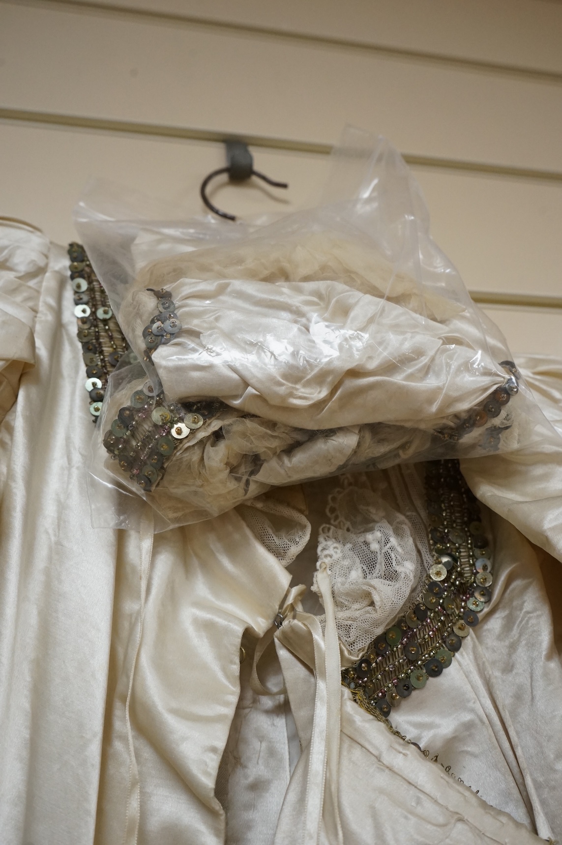A cream silk satin theatrical costume, mounted with sequined braiding and pair of novelty shoes. Bust measurement 30inches.